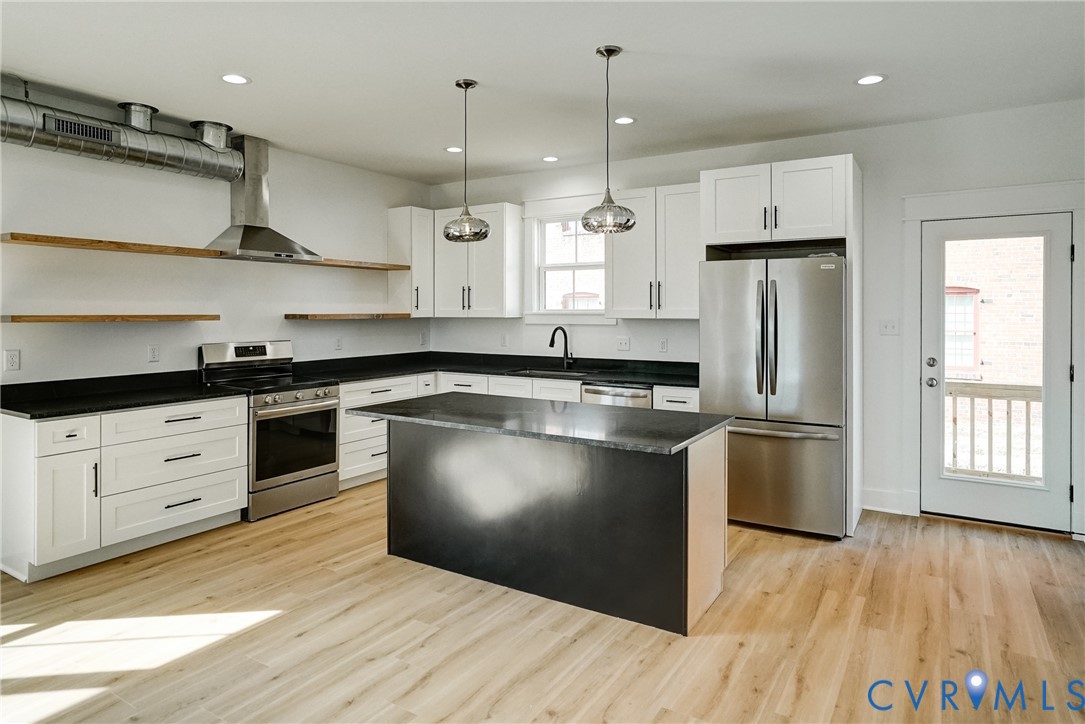 901 Commerce Street Petersburg, VA 23803 - Photo 16 of 40 a kitchen with stainless steel appliances granite countertop a refrigerator a sink dishwasher a stove and white countertops with wooden floor