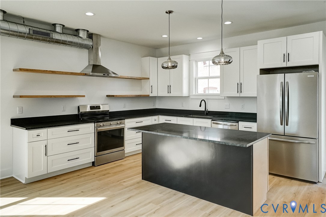 901 Commerce Street Petersburg, VA 23803 - Photo 17 of 40 a kitchen with stainless steel appliances granite countertop a sink a stove a refrigerator and island with wooden floor
