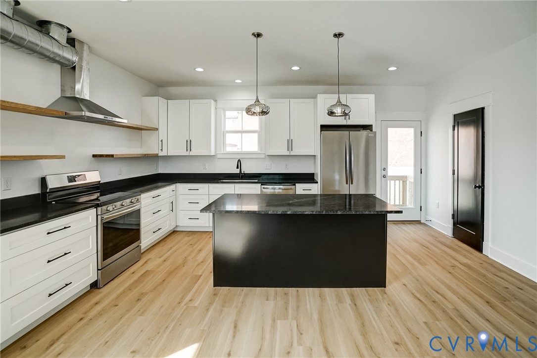 901 Commerce Street Petersburg, VA 23803 - Photo 18 of 40 a kitchen with stainless steel appliances granite countertop a stove a sink and a refrigerator