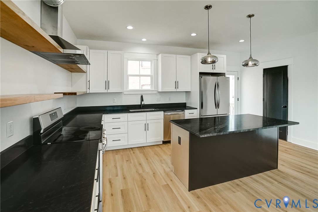 901 Commerce Street Petersburg, VA 23803 - Photo 19 of 40 a kitchen with stainless steel appliances granite countertop a sink a stove and a refrigerator