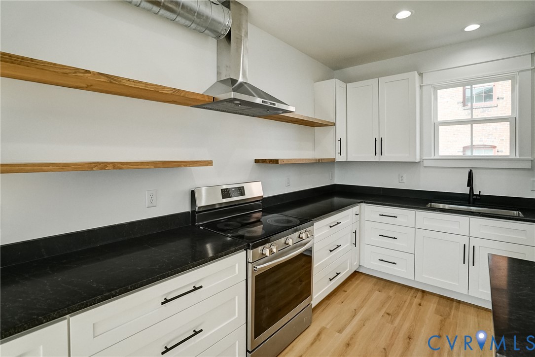 901 Commerce Street Petersburg, VA 23803 - Photo 20 of 40 a kitchen with granite countertop stainless steel appliances a sink a stove and cabinets