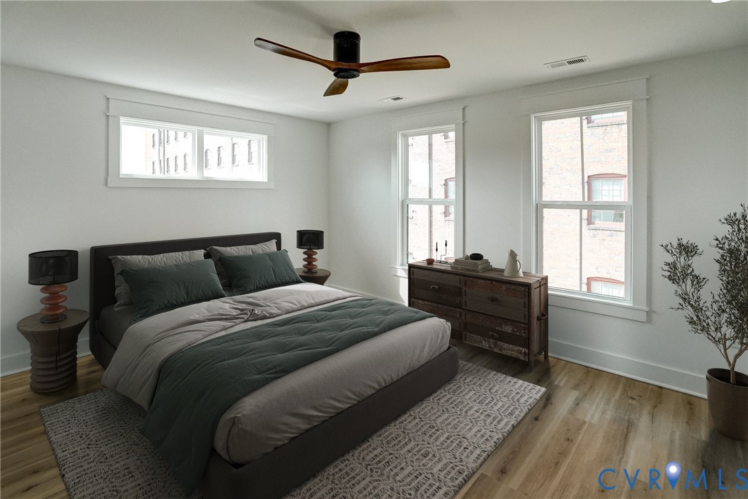 901 Commerce Street Petersburg, VA 23803 - Photo 28 of 40 a bedroom with a bed and wooden floor