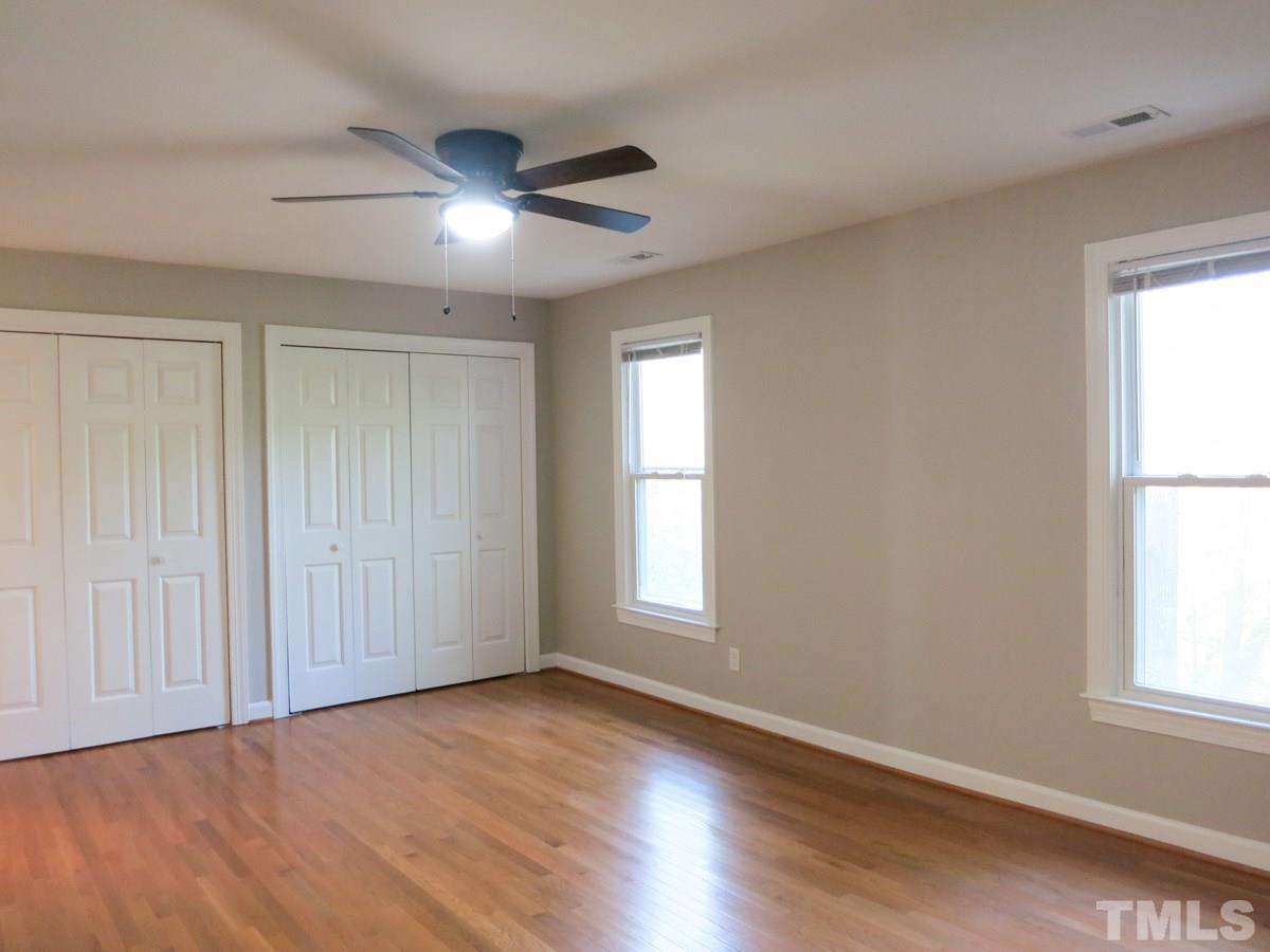 6820 Gloucester Road Raleigh, NC 27612 - Photo 11 of 25 an empty room with wooden floor and windows