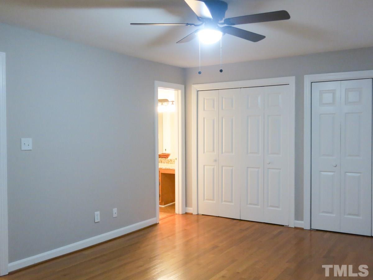 6820 Gloucester Road Raleigh, NC 27612 - Photo 12 of 25 an empty room with wooden floor closet and windows