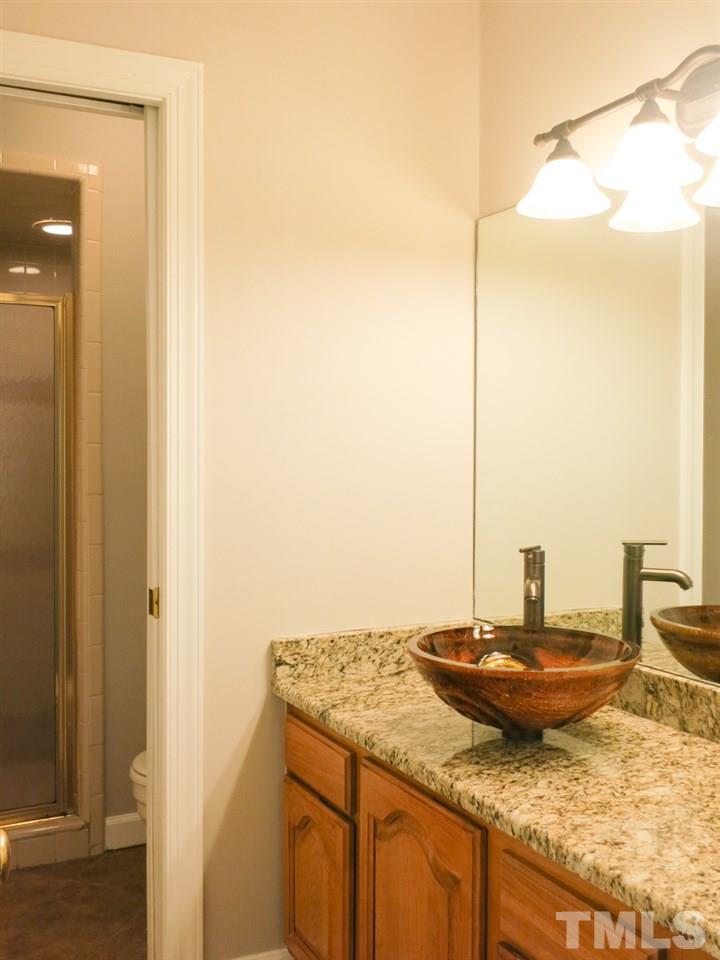 6820 Gloucester Road Raleigh, NC 27612 - Photo 13 of 25 a bathroom with a granite countertop sink and a mirror