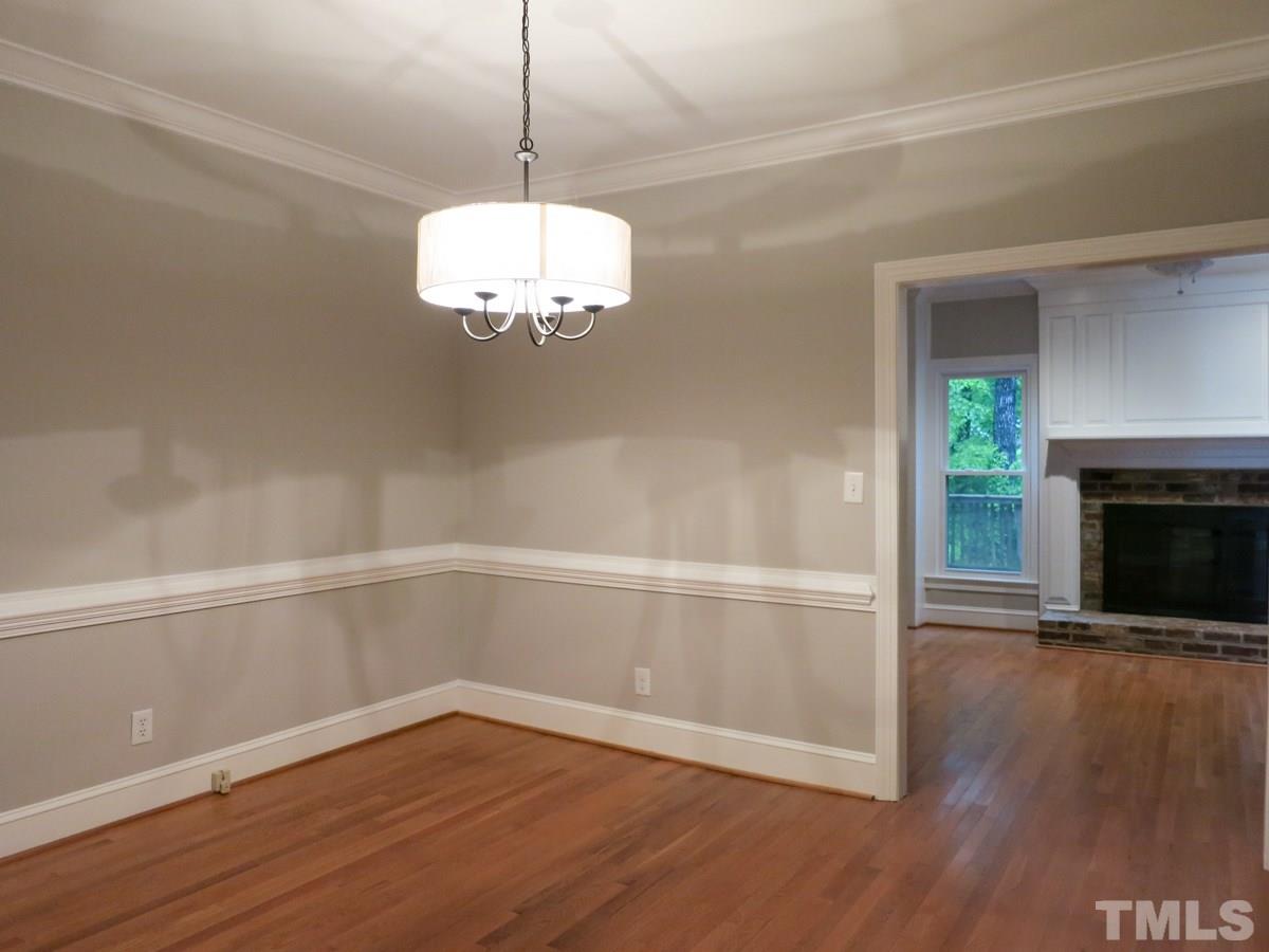 6820 Gloucester Road Raleigh, NC 27612 - Photo 7 of 25 a view of a room with wooden floor fireplace and window