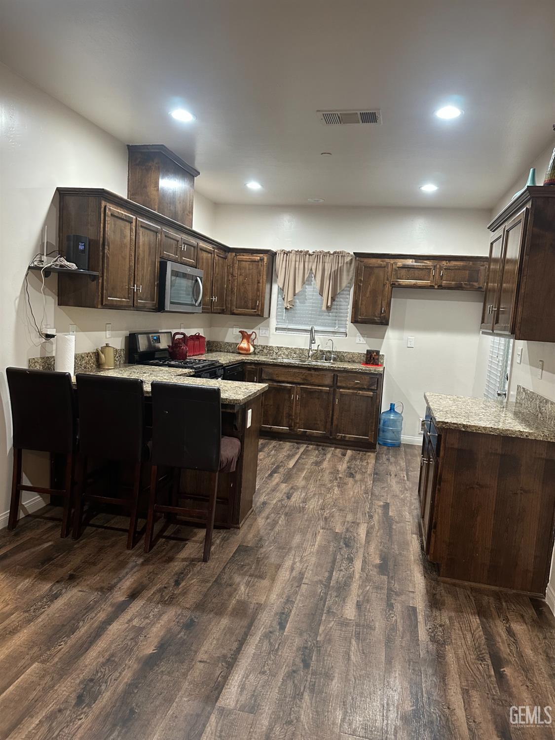 Undisclosed Address Wasco, CA 93280 - Photo 6 of 24 a kitchen with cabinets a sink and chairs in it
