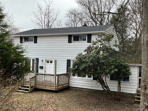 a view of a house with a yard and deck