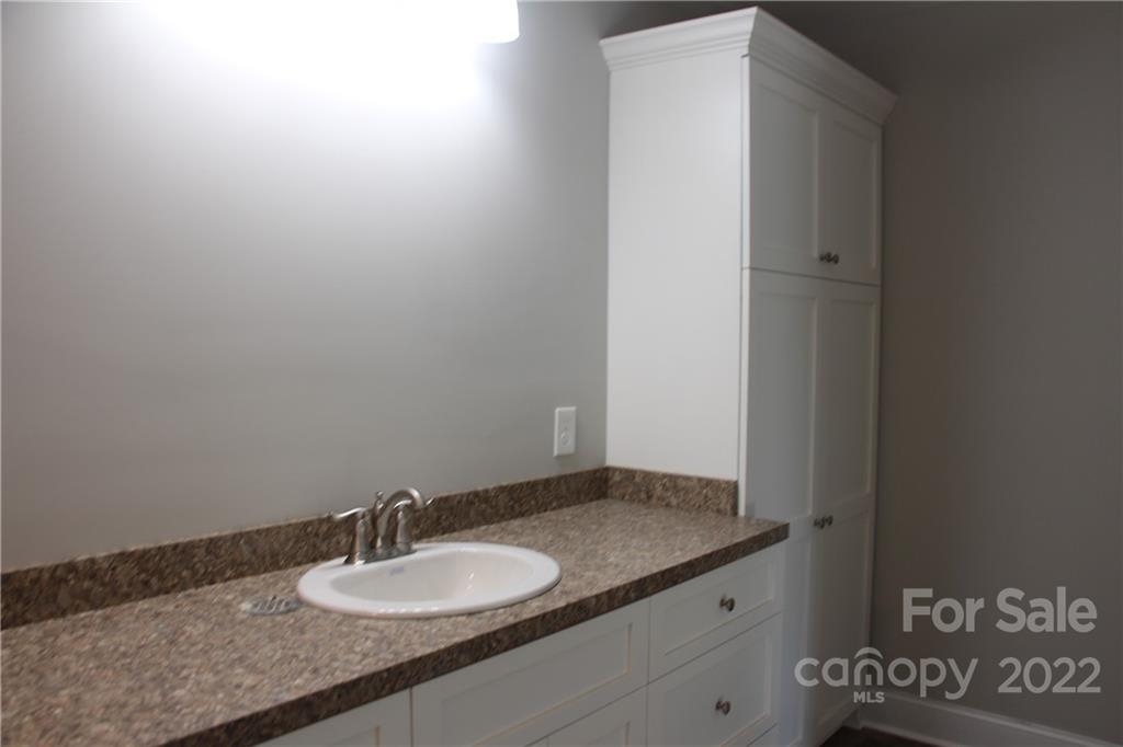 4256 Fletcher Funderburk Road Lancaster, SC 29720 - Photo 11 of 18 a bathroom with a granite countertop sink and a mirror