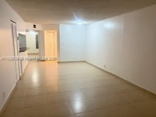 an empty room with wooden floor and bathroom