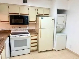 a kitchen with a stove top oven and refrigerator