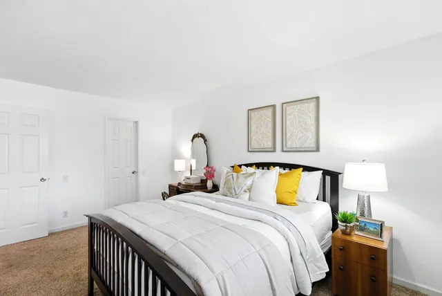 a bedroom with a bed and a painting on the wall