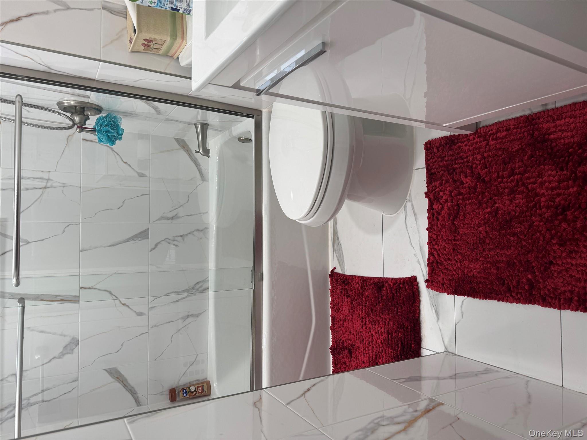 Undisclosed Address Hempstead, NY 11550 - Photo 4 of 5 Full bathroom featuring marble look tile flooring, combined bath / shower with glass door, and vanity