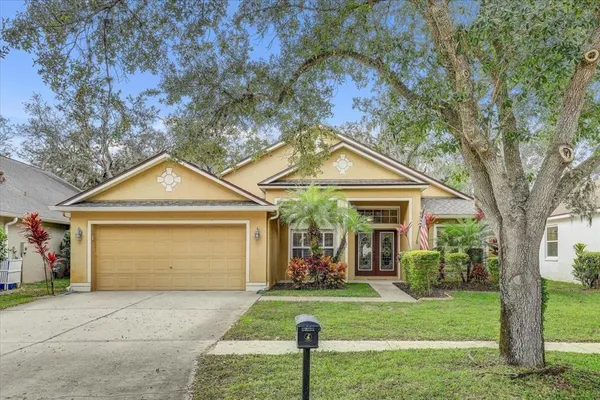 a front view of a house with a yard and trees