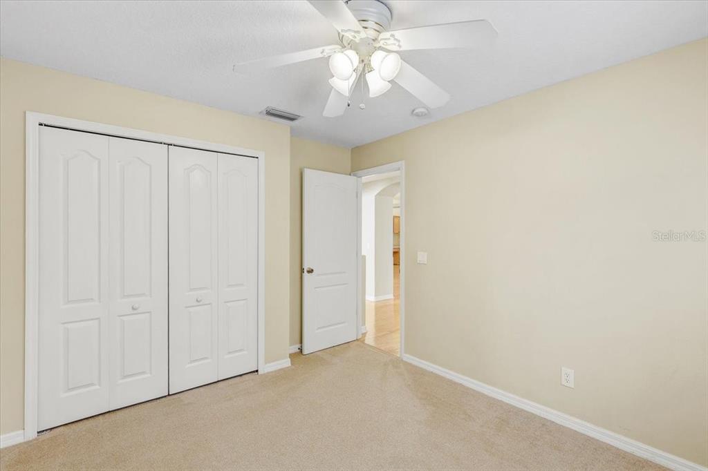 15129 Shearcrest Drive Lithia, FL 33547 - Photo 35 of 48 an empty room with a chandelier fan and closet area