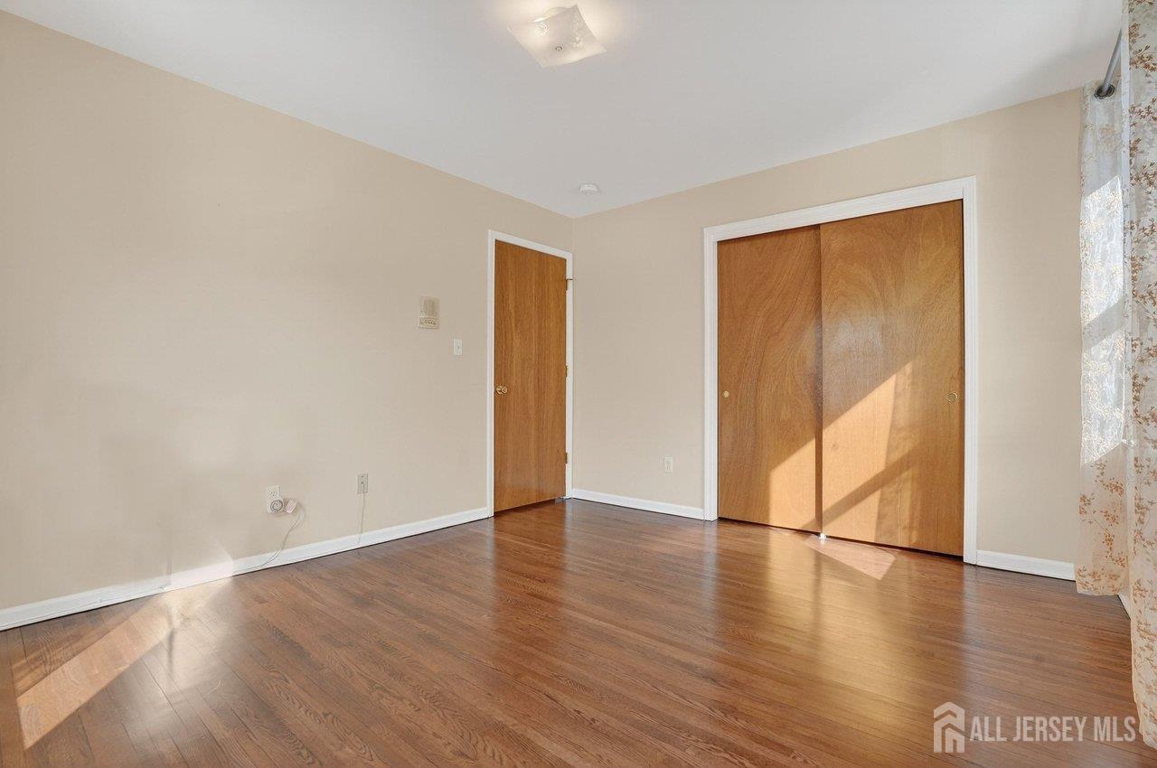 1 Wakefield Drive Edison, NJ 08820 - Photo 17 of 29 a view of an empty room with wooden floor and a window
