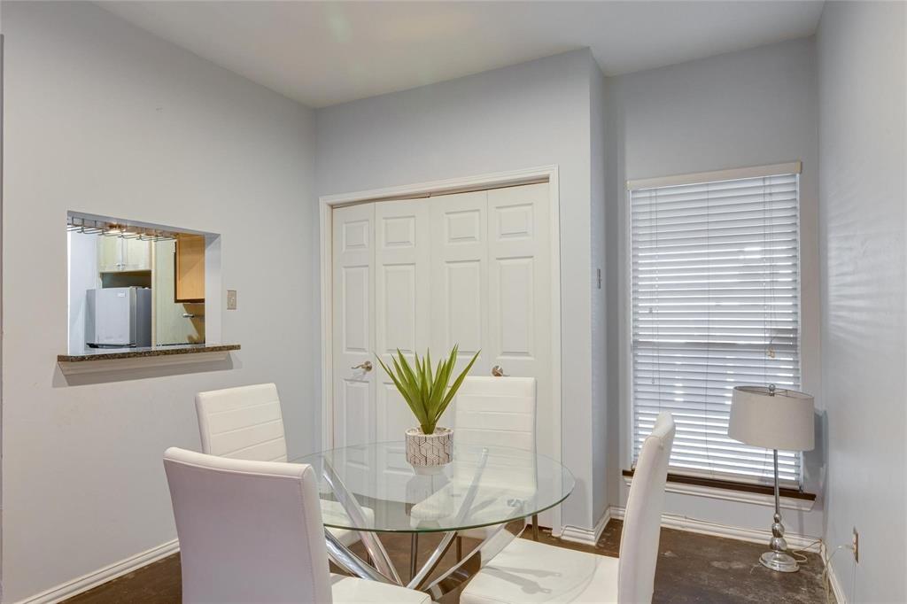4104 North Hall Street, Unit 102 Dallas, TX 75219 - Photo 13 of 18 Dining area featuring a pass-through window with granite countertop, a full-height window with horizontal blinds, bi-fold closet doors, and light gray wall paint