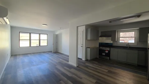 an empty room with windows and cabinet