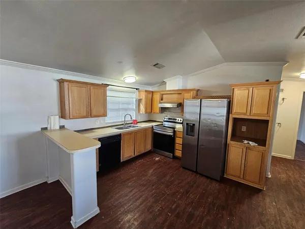 a kitchen with refrigerator cabinets and wooden floor