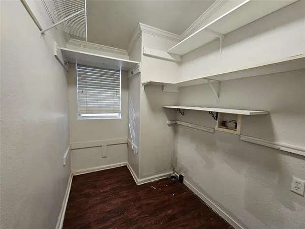 a view of a room with wooden floor and a window