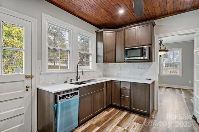 a kitchen with granite countertop stainless steel appliances and wooden cabinets