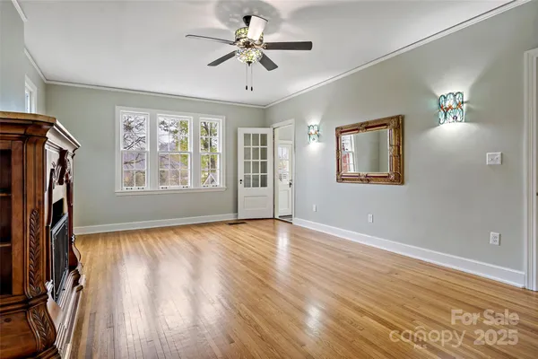 a view of empty room with fireplace and wooden floor