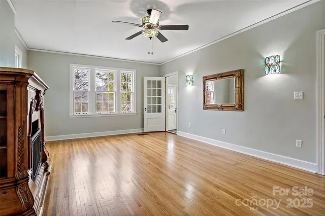a view of empty room with fireplace and wooden floor