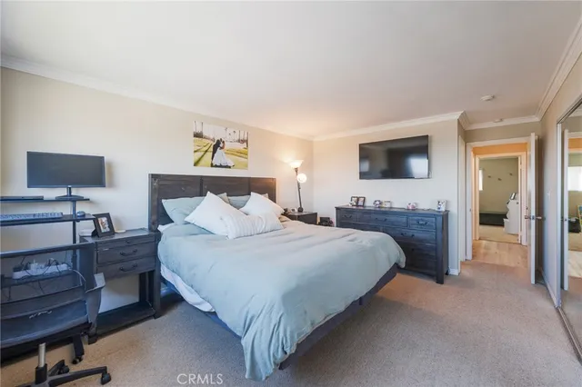 a spacious bedroom with a bed and a flat screen television