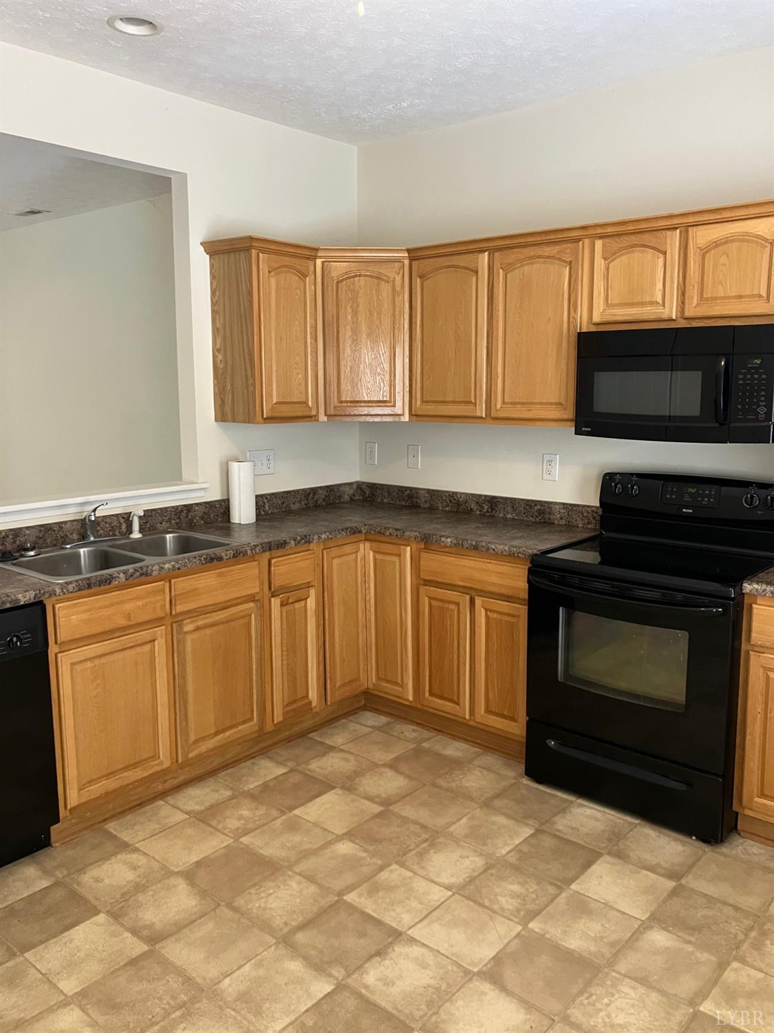 1600 Wards Ferry Road, Unit 103 Lynchburg, VA 24502 - Photo 9 of 23 a kitchen with granite countertop a stove top oven microwave and cabinets