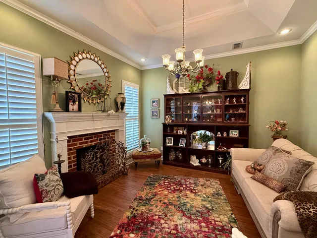 a living room with furniture a chandelier and a fireplace