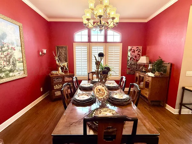 a view of a dining room with furniture a chandelier and wooden floor