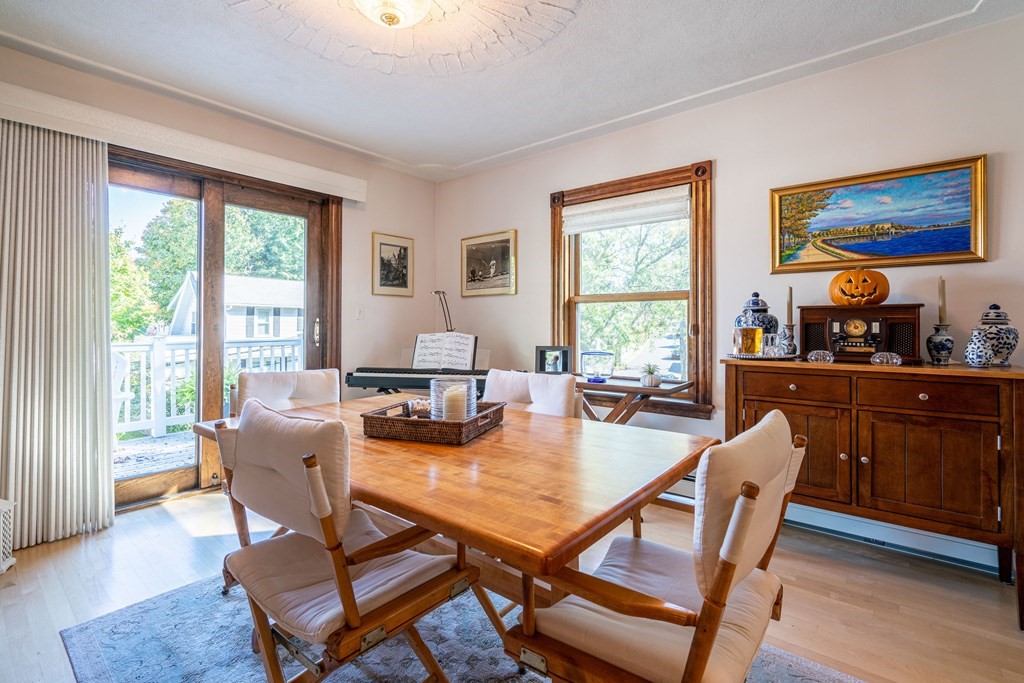 55 Waldeck Road Milton, MA 02186 - Photo 3 of 28 a dining room with wooden floor windows a glass table and chairs
