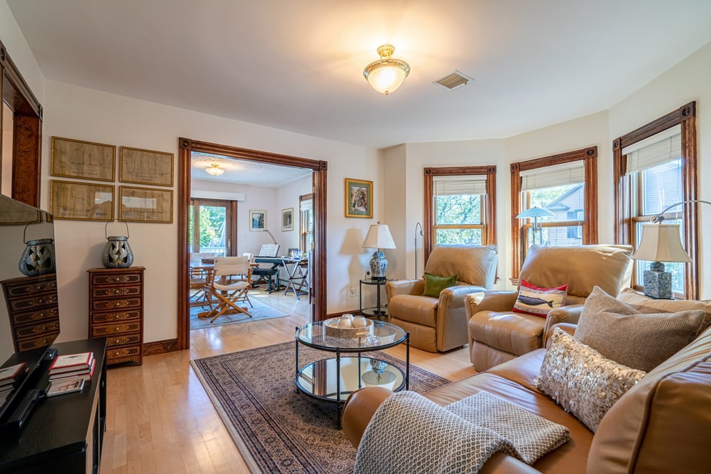 55 Waldeck Road Milton, MA 02186 - Photo 6 of 28 a living room with furniture a flat screen tv and large windows