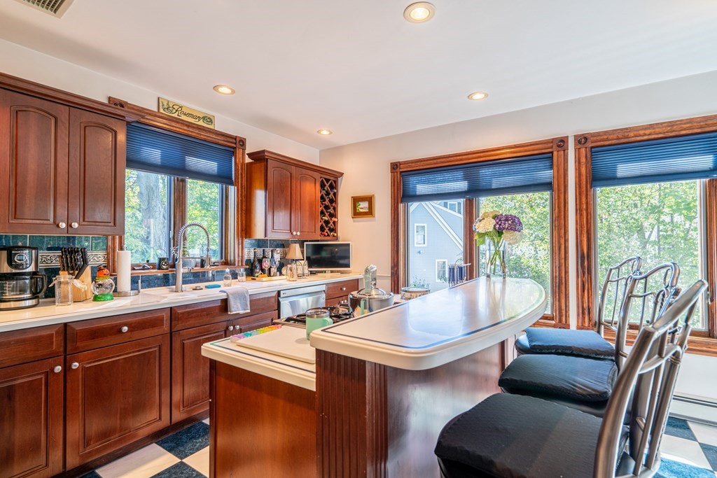 55 Waldeck Road Milton, MA 02186 - Photo 8 of 28 a kitchen with a table chairs stove and cabinets