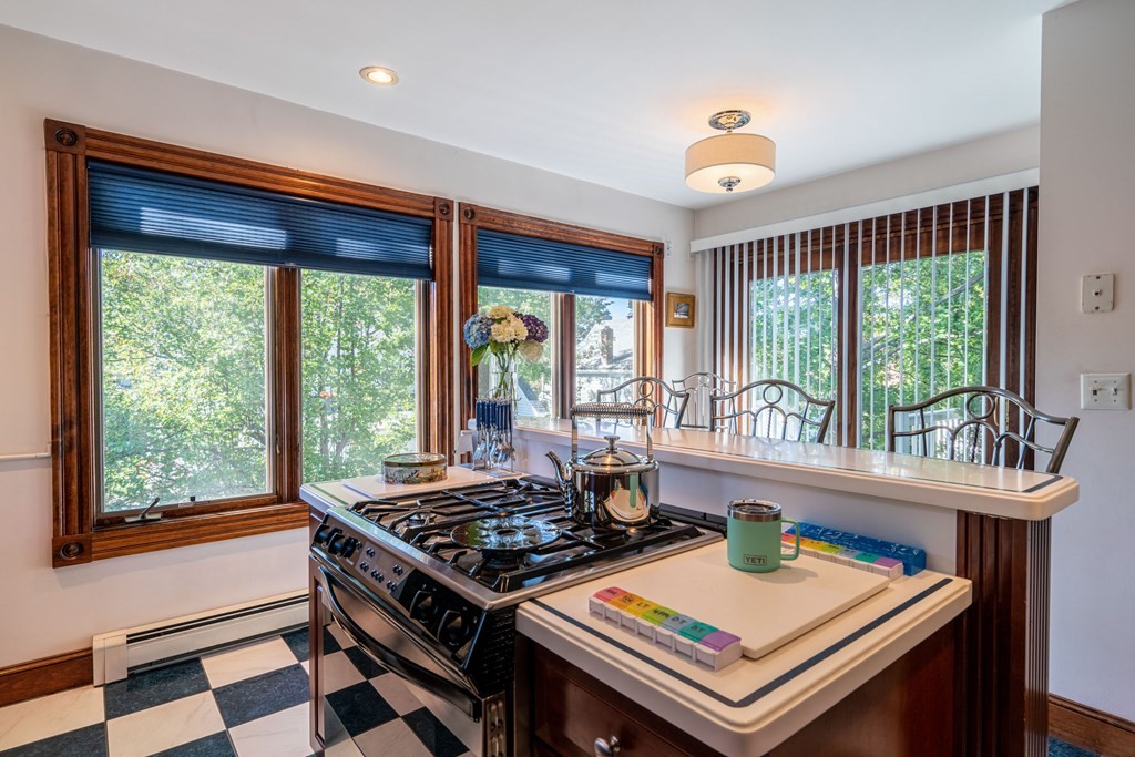 55 Waldeck Road Milton, MA 02186 - Photo 9 of 28 a kitchen with a stove a sink and a dining table