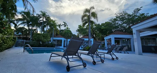 a view of house with swimming pool and outdoor seating