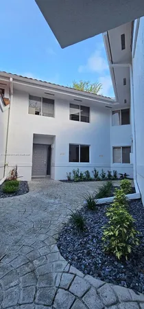 a front view of a house with a yard and trees
