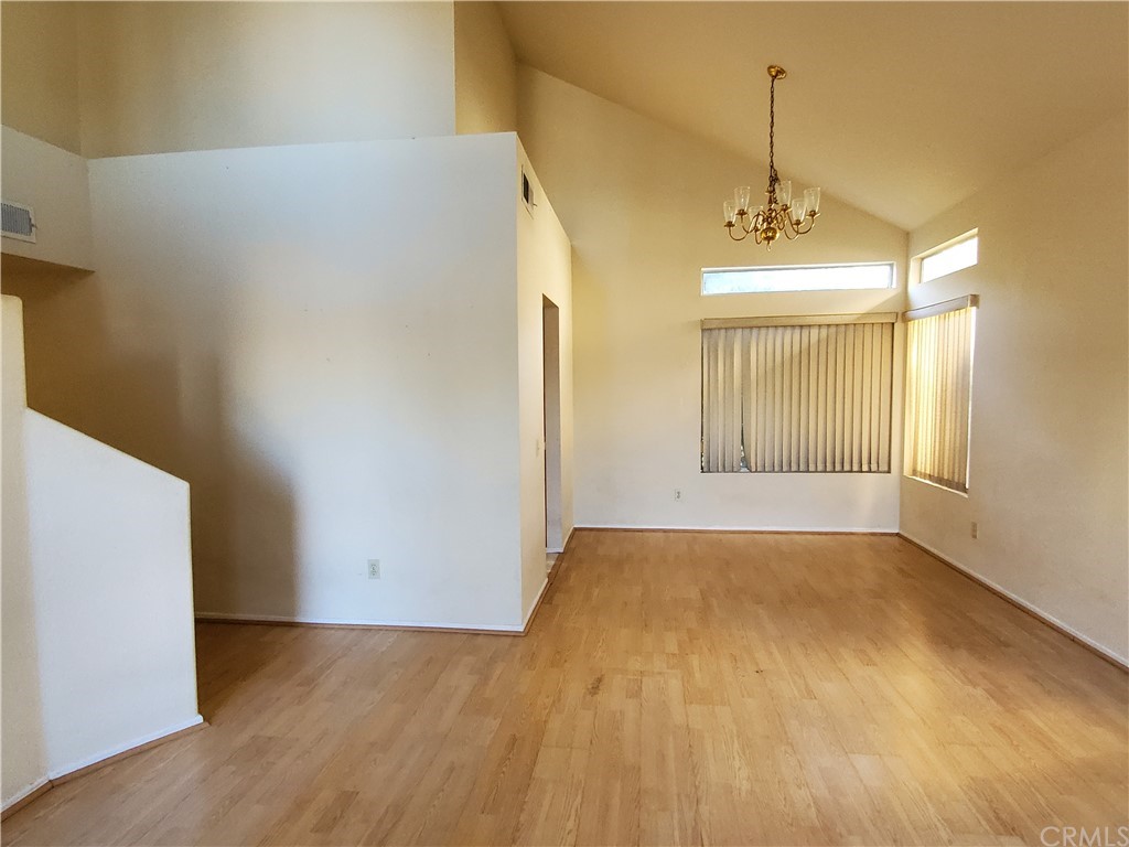 39837 Falcon Way Murrieta, CA 92562 - Photo 3 of 12 an empty room with wooden floor and windows