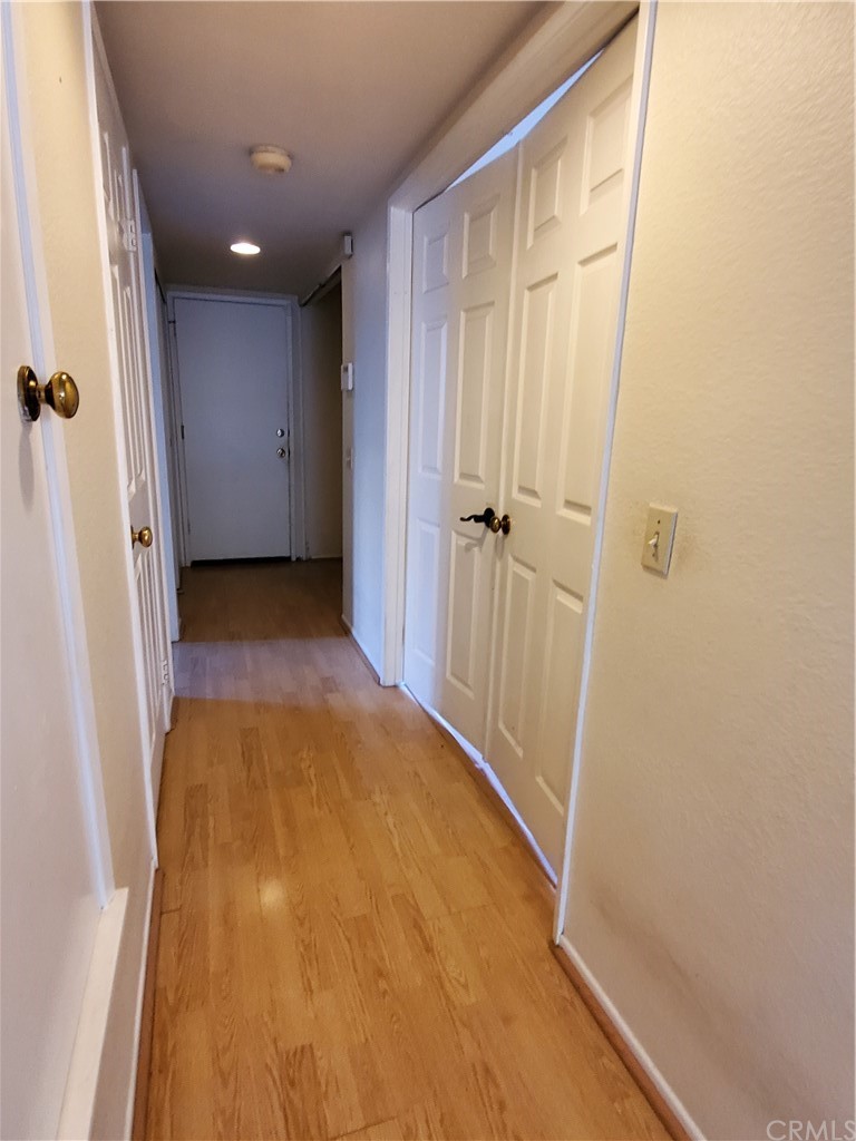 39837 Falcon Way Murrieta, CA 92562 - Photo 6 of 12 a view of a hallway with wooden floor and a bathroom