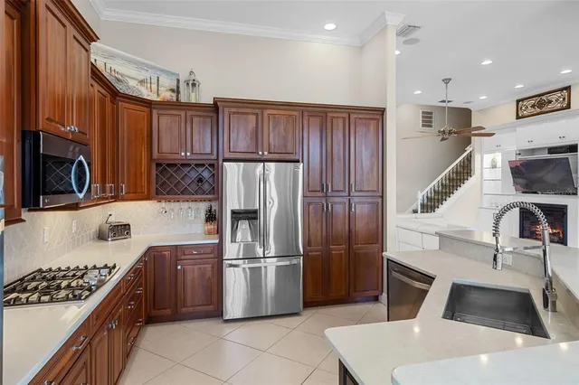 a kitchen with kitchen island stainless steel appliances cabinets a sink and a counter top space