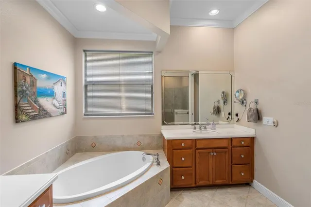 a spacious bathroom with a tub sink and mirror