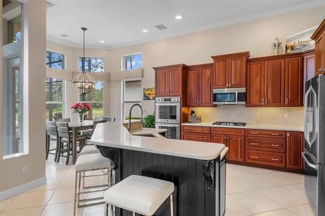 a kitchen with stainless steel appliances a table chairs and a refrigerator
