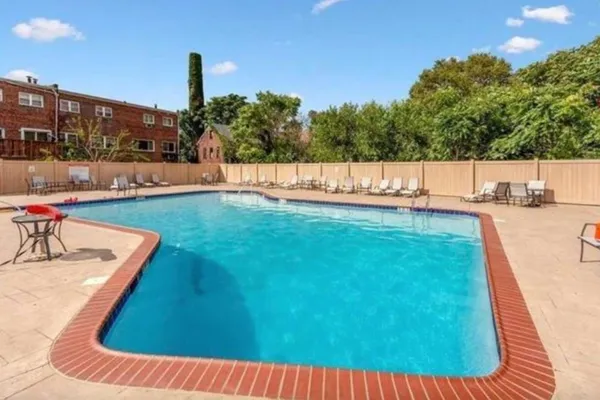 a view of a swimming pool with a patio and a yard
