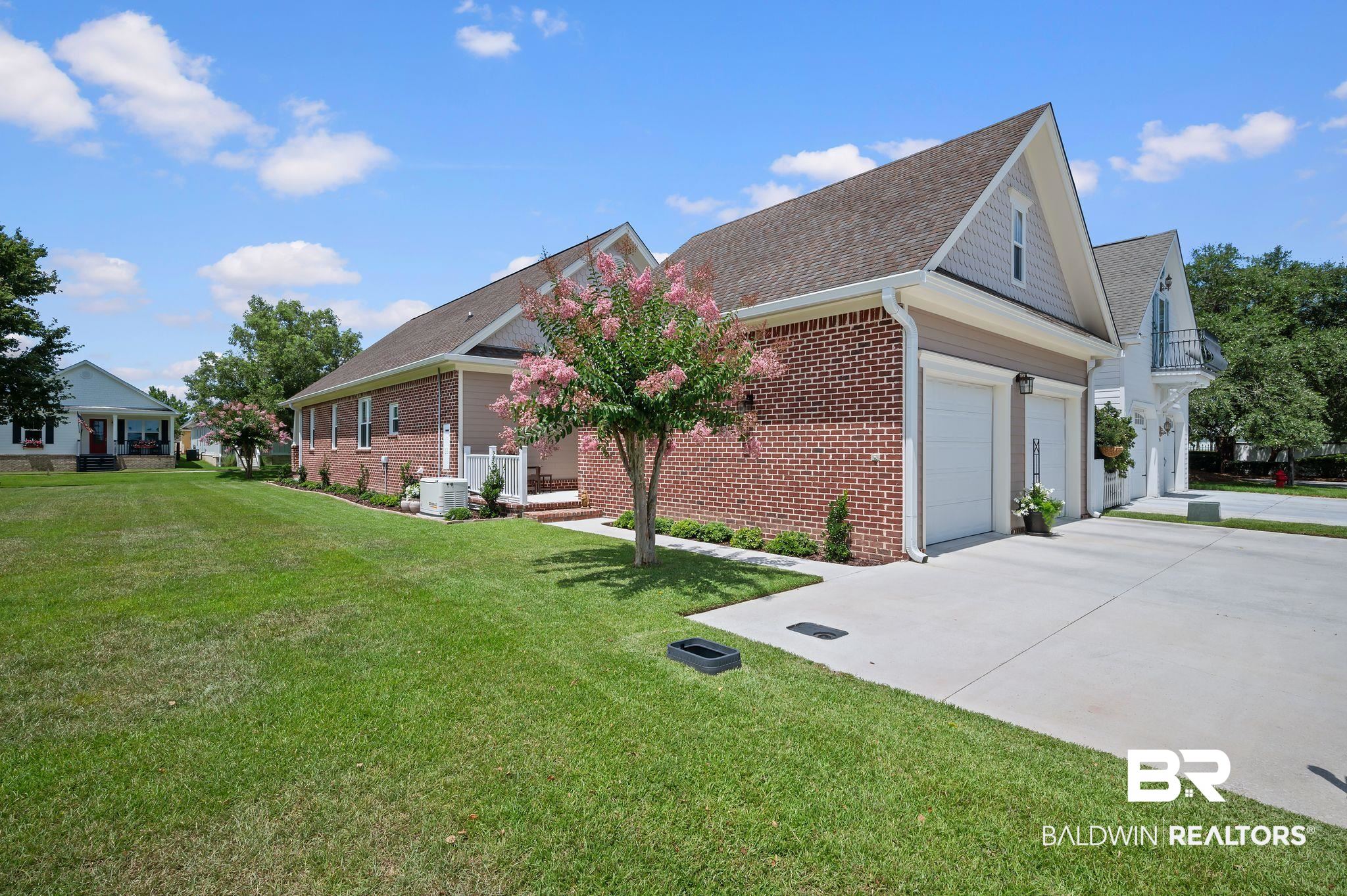 905 Buttercup Lane Foley, AL 36535 - Photo 9 of 47 View of property exterior with brick siding, concrete driveway, a yard, and a shingled roof