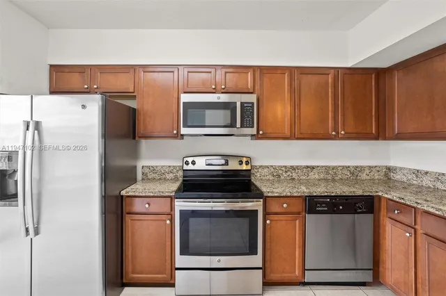 a kitchen with stainless steel appliances granite countertop a stove microwave and refrigerator