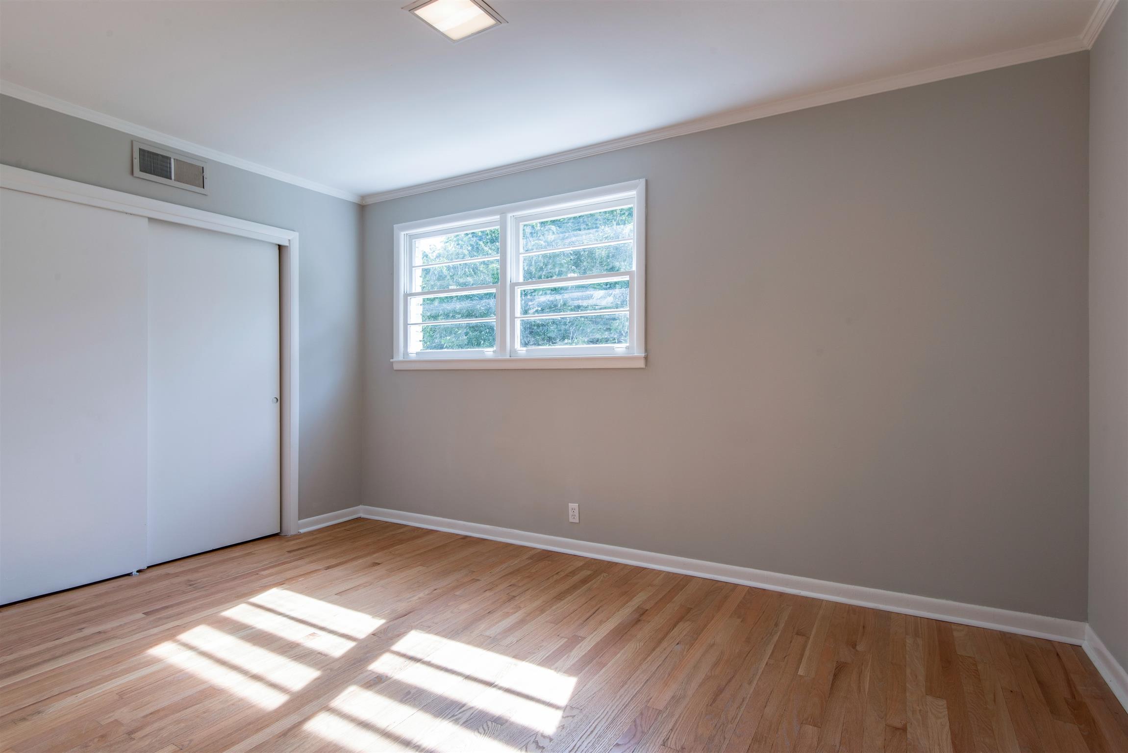 110 Dabney Drive Franklin, TN 37064 - Photo 11 of 25 a view of an empty room with wooden floor and a window