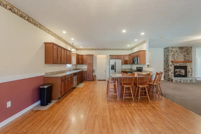 a kitchen with stainless steel appliances granite countertop a refrigerator stove top oven a sink and dishwasher