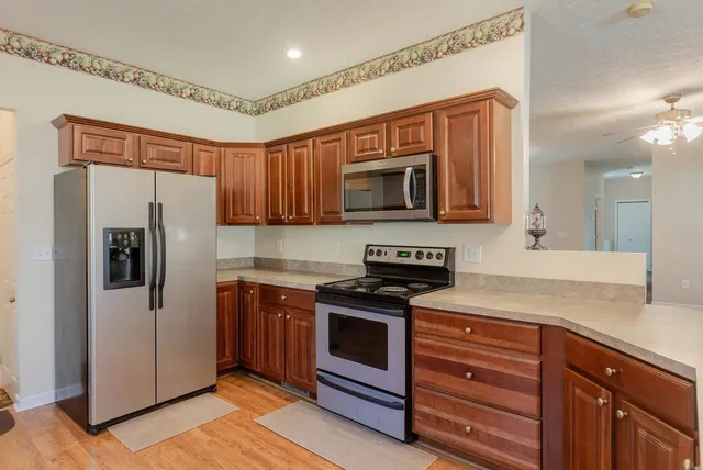 a kitchen with granite countertop cabinets stainless steel appliances and wooden cabinets