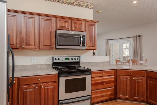an empty room with chandelier fan and windows