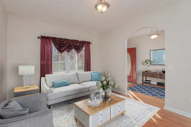 a living room with furniture a chandelier and a dining table